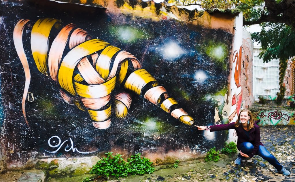 girl pretending to touch graffiti finger on the wall