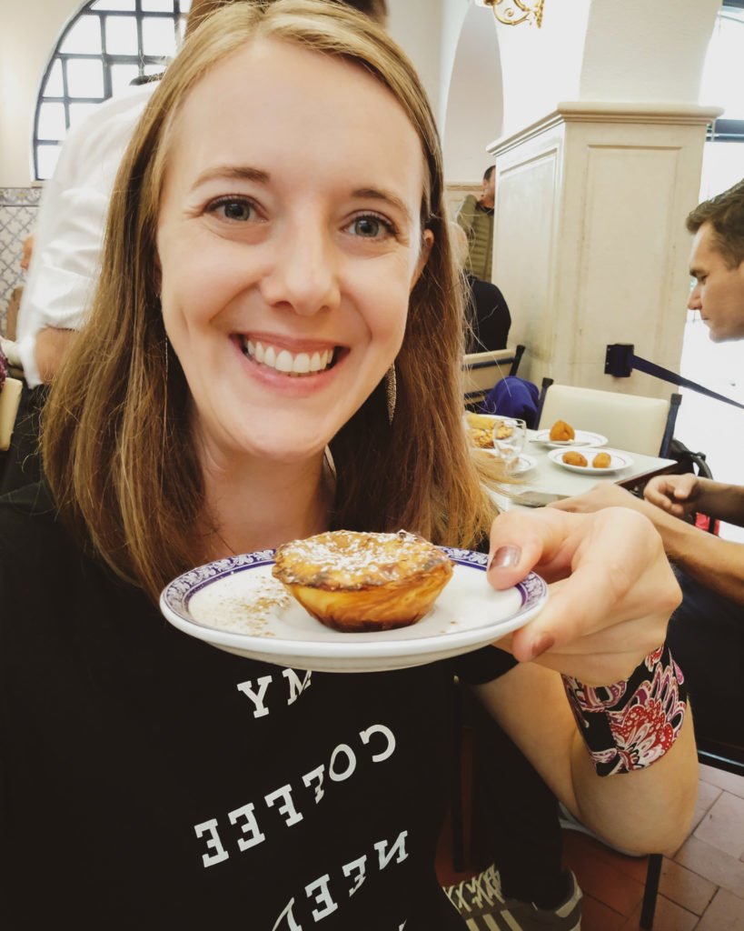 Girl eating Portuguese custard in Lisbon