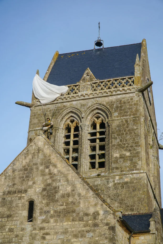A mannequin of a paratrooper hanging from the church steeple in Sainte-Mere-Eglise.
