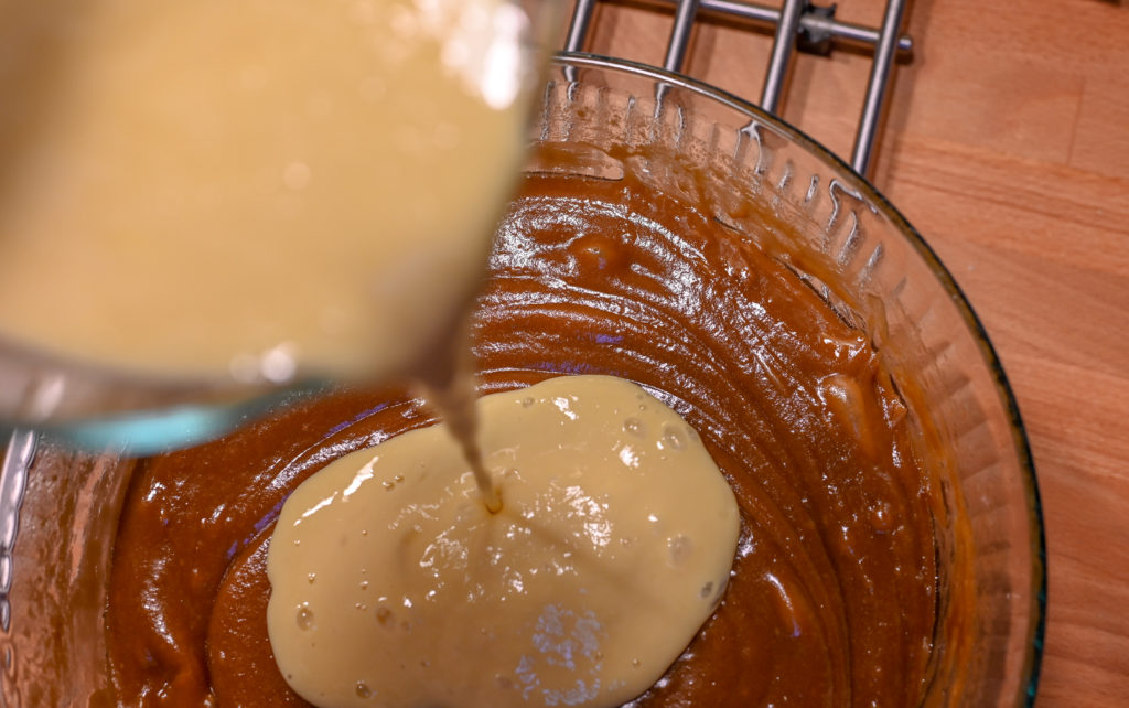 buttermilk and eggs being poured into cake batter