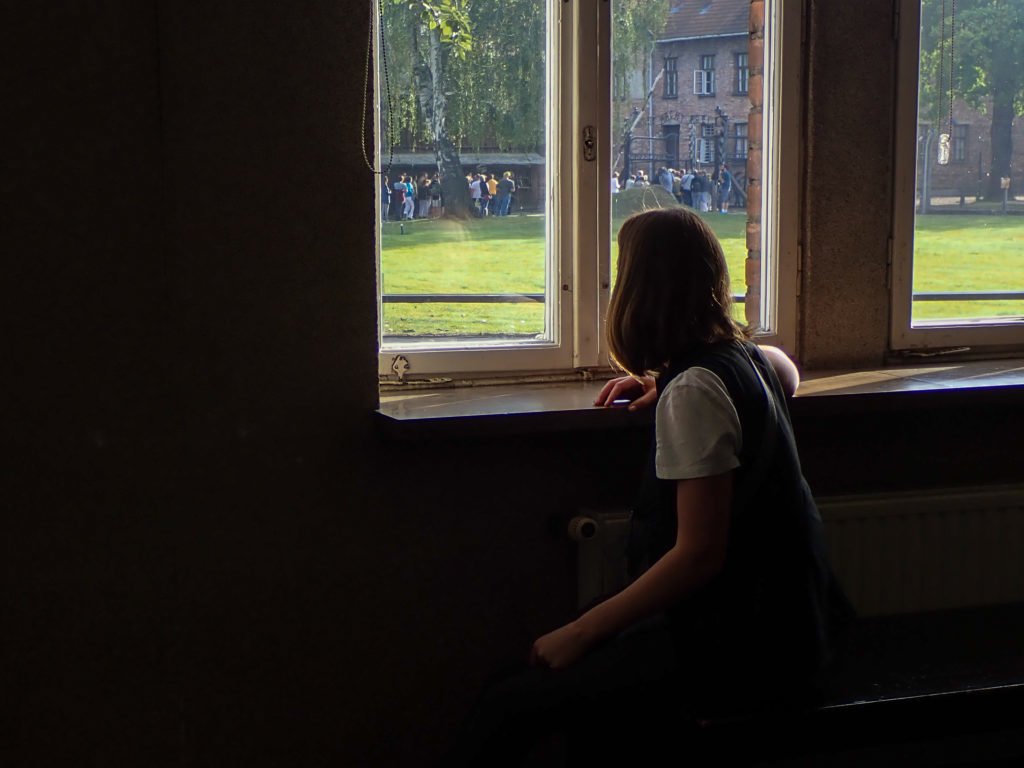 Woman looking out window at Auschwitz museum