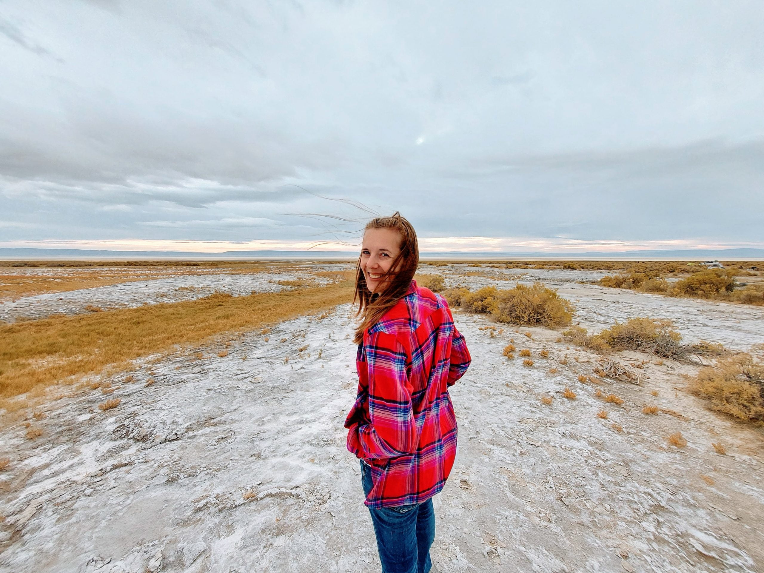 woman standing on white mineral rich soil in the desert