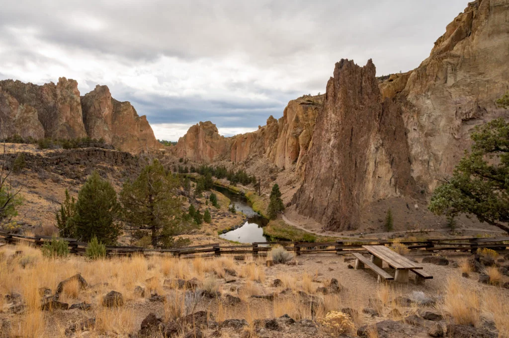 a picnic table with view of smith rock state park