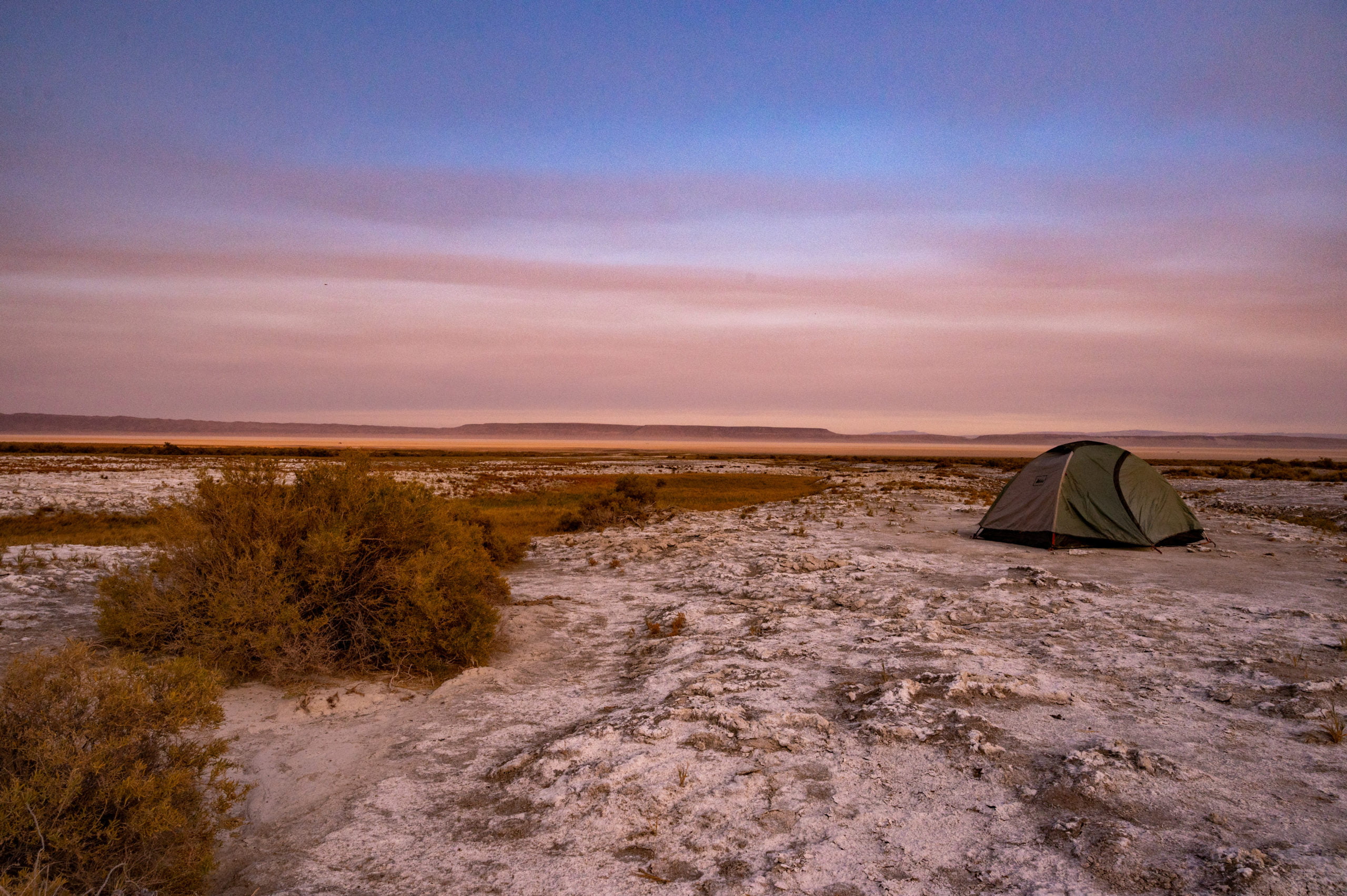 tent in desert at sunset